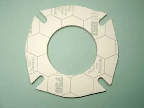 Dichtung aus einem Material mit hexagonalem Muster, verwendet in Heizsystemen, möglicherweise von Remeha, mit einem kreisförmigen Loch in der Mitte und Ausschnitten an den Seiten.